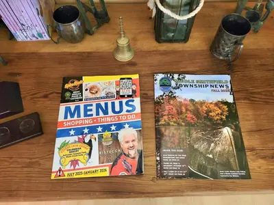 two magazines sitting on top of a wooden table at Shawnee Ski Mountain View Jacuzzi Townhouse in East Stroudsburg