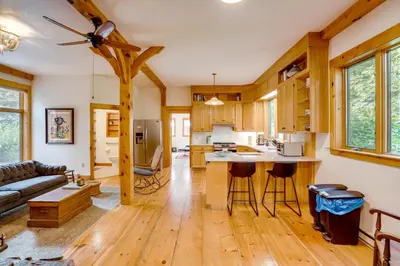 a kitchen and living room with wood floors and a couch at Secluded Family Getaway with On-Site Creek in Hawley in Hawley