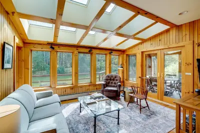 a living room with wooden walls and windows at Secluded Family Getaway with On-Site Creek in Hawley in Hawley