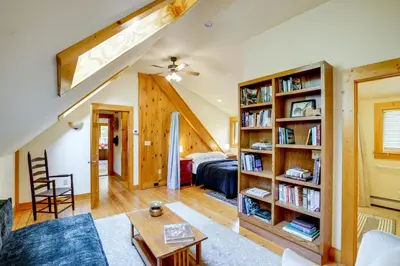 a living room with a bed and a book shelf at Secluded Family Getaway with On-Site Creek in Hawley in Hawley