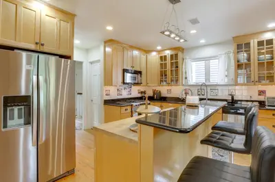 a kitchen with wooden cabinets and a stainless steel refrigerator at Walk to Hudson River Waterfront Newburgh Home in Newburgh