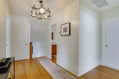 an empty living room with white walls and a chandelier at Walk to Hudson River Waterfront Newburgh Home in Newburgh