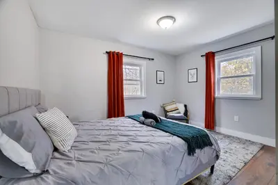 a bedroom with a bed and two windows at Winter retreat, hot tub, game room, indoor pool, in Long Pond