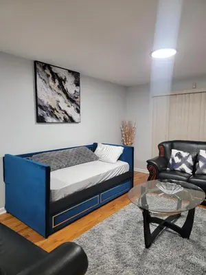 a room with a bed and a couch and a table at Urban Nest in Newark