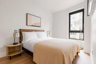 a white bedroom with a large bed and a window at Blueground Williamsburg rooftop nr McCarren Park NYC-2076 in Brooklyn