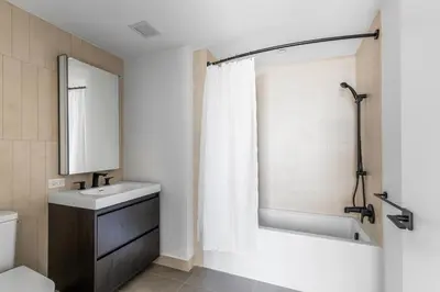 a bathroom with a tub and a sink and a toilet at Blueground Alphabet City rooftop nr Tompkins Square Park NYC-2081 in New York