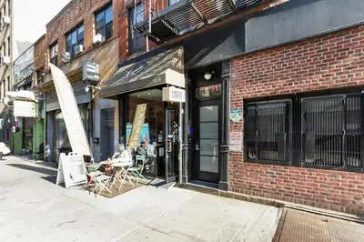a store front of a brick building with chairs outside at Blueground Hells Kitchen terrace nr Times Square NYC-2063 in New York