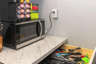 a kitchen counter with a microwave and a bunch of tools at Downtown Studio Very Cozy in Albany