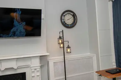 a clock on a wall next to a fireplace at Downtown Studio Very Cozy in Albany