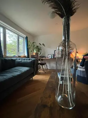 a living room with a large glass vase on a table at 1 BEDROOM WITH SLEEPING IN LIVING ROOM Williamburg in Brooklyn