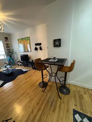 a living room with a table and chairs in it at Modern Stay in Downtown Jersey City, Close to NYC! in Jersey City