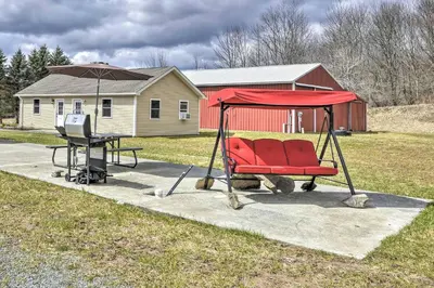 a red chair and a table with an umbrella at Triple Suites Close to Skiing in Pleasant Mount