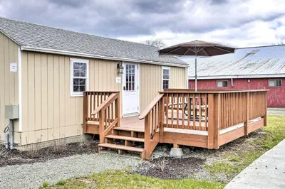 a house with a large deck with an umbrella at Quadruple Suites At Equestrian House in Pleasant Mount