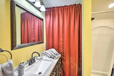 a bathroom with a sink and a red shower curtain at Quadruple Suites At Equestrian House in Pleasant Mount