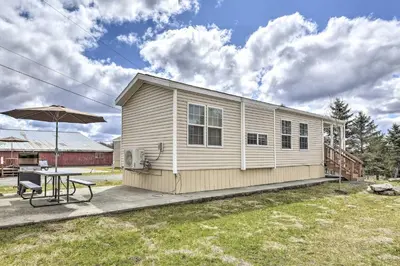 a small house with a table and an umbrella at Premium Cottages And Suites At Equestrian House in Pleasant Mount