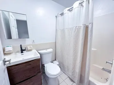 a bathroom with a toilet and a sink and a shower at Residence Heritage Giant 3 Bedroom in New York