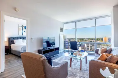 a living room with a bed a couch and a tv at Luxury Apartment in Stamford - Gym & Pool Access in Stamford