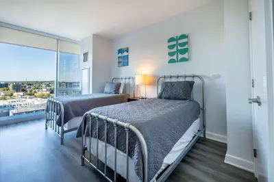 two beds in a bedroom with a balcony at Luxury Apartment in Stamford - Gym & Pool Access in Stamford