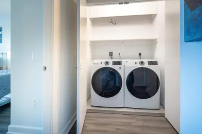 a washer and dryer in a laundry room at Luxury Apartment in Stamford - Gym & Pool Access in Stamford