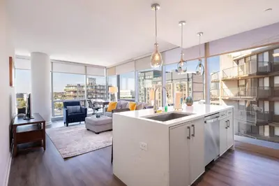 a kitchen with a sink and a living room at Chic Stamford Apartment - Walk to Train & Entertainment in Stamford