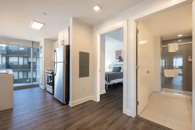 a kitchen with a refrigerator and a room with a bed at Chic Stamford Apartment - Walk to Train & Entertainment in Stamford