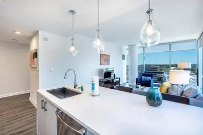 a kitchen with a sink and a living room at Chic Stamford Apartment - Walk to Train & Entertainment in Stamford