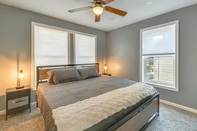 a bedroom with a bed and two windows at Walk to Main Street! Updated Norwich Home in Norwich