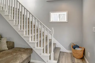 a white staircase with a couch and a window at Walk to Main Street! Updated Norwich Home in Norwich