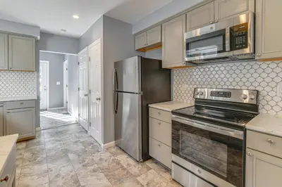 a kitchen with a stainless steel refrigerator and cabinets at Walk to Main Street! Updated Norwich Home in Norwich