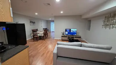 a living room with a couch and a table with a television at Work & Stay - NYC - EWR - Train Walk in Newark