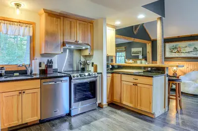 a kitchen with wooden cabinets and stainless steel appliances at Hike, Ski and Relax Renovated Retreat in Wilmington in Wilmington