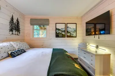 a bedroom with a bed and a desk and windows at Hike, Ski and Relax Renovated Retreat in Wilmington in Wilmington