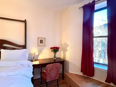 a bedroom with a bed and a desk and a window at Luxurious bedroom in New York