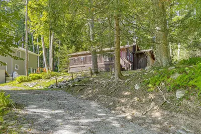 a house in the woods next to a dirt road at Boat, Hike and Fish Rustic Greenwood Retreat in Greentown