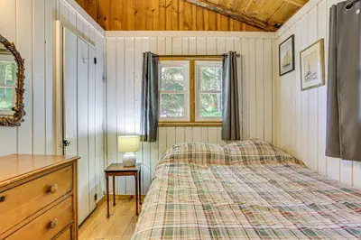 a bedroom with a bed and a dresser and a window at Boat, Hike and Fish Rustic Greenwood Retreat in Greentown