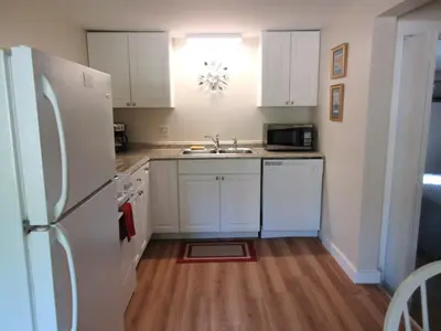 a kitchen with a white refrigerator and a sink at McGregor Inn Motel in Saratoga Springs
