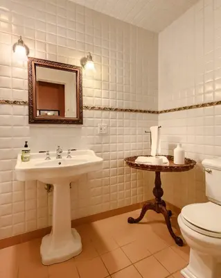 a bathroom with a sink and a toilet and a mirror at Elegant 7BR Estate with Pool & Hot Tub in Berkshires in North Egremont