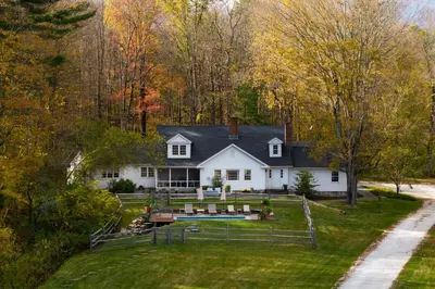 a white house with a pool in the yard at Elegant 7BR Estate with Pool & Hot Tub in Berkshires in North Egremont
