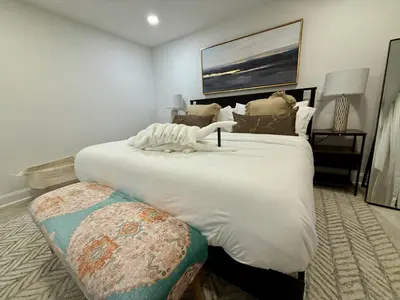 a large white bed with a bench in a room at Top Luxe Oasis -Ski, Hike, Firepit, Spa, Golf in Vernon Township