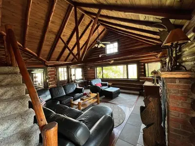 a living room with leather furniture in a log cabin at Stony Creek Lodge in East Stroudsburg