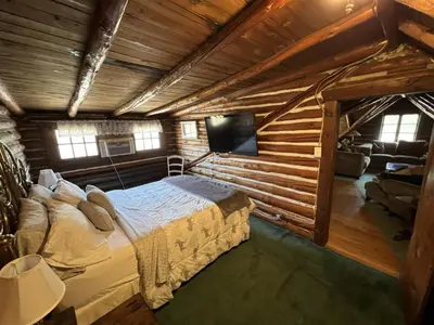 a bedroom with a bed in a log cabin at Stony Creek Lodge in East Stroudsburg