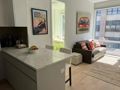a kitchen and living room with a table and a couch at Brooklyn - Dumbo - 2-bedroom, 2-bath apartment in Brooklyn
