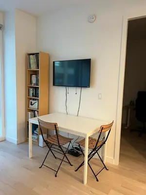 a table with two chairs and a television on a wall at Brooklyn - Dumbo - 2-bedroom, 2-bath apartment in Brooklyn