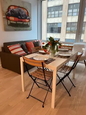 a table and chairs in a living room with a couch at Brooklyn - Dumbo - 2-bedroom, 2-bath apartment in Brooklyn