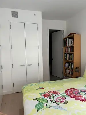 a bedroom with a bed with a floral bedspread at Brooklyn - Dumbo - 2-bedroom, 2-bath apartment in Brooklyn