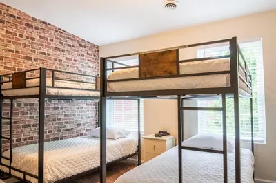 two bunk beds in a room with a brick wall at Downtown Albany, Hot Tub, Game Room, eV Charger in Albany