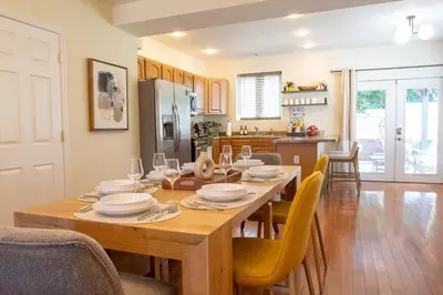 a dining room with a wooden table and yellow chairs at Downtown Albany, Hot Tub, Game Room, eV Charger in Albany