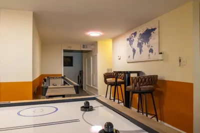 a room with a ping pong table and chairs at Downtown Albany, Hot Tub, Game Room, eV Charger in Albany