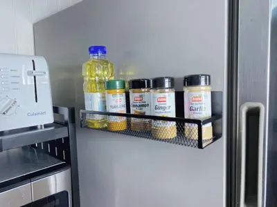 a refrigerator with jars of food on a shelf at Premium convenient stays in Manchester