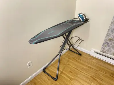 a surfboard on a stand in the corner of a room at Premium convenient stays in Manchester